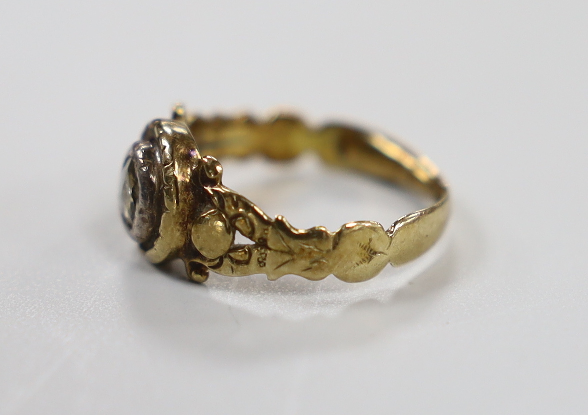 An early 19th century yellow metal and collet set rose cut diamond ring, with carved shoulders, size F, gross weight 2.4 grams.